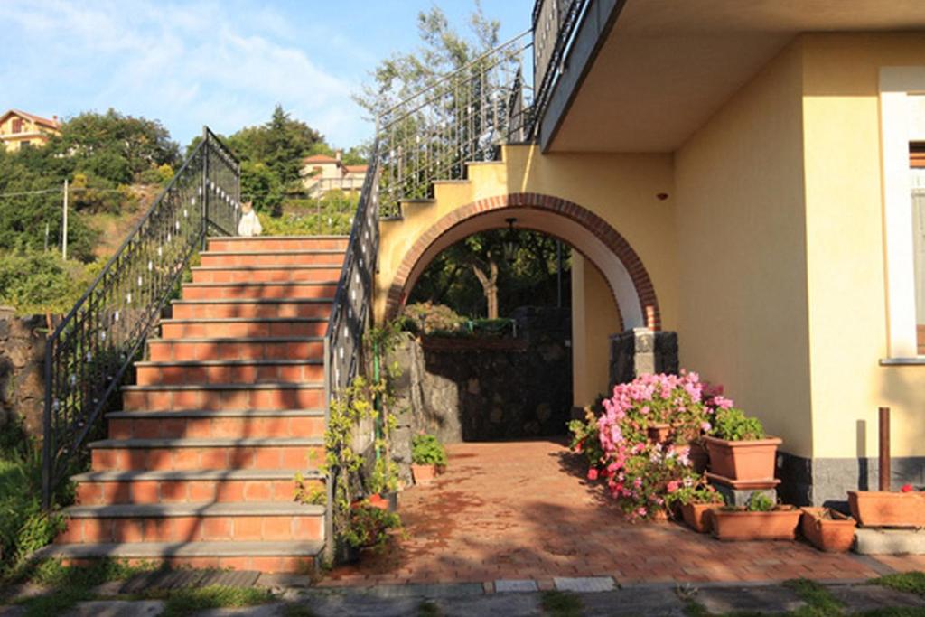 un conjunto de escaleras que conducen a una casa con flores en Biologico Dell'Etna en Trecastagni