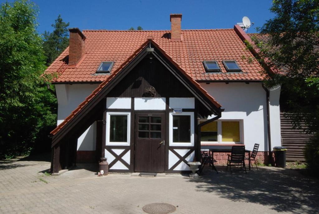 a house with a wooden door and a table and chairs at Noclegi Dorotowo in Dorotowo