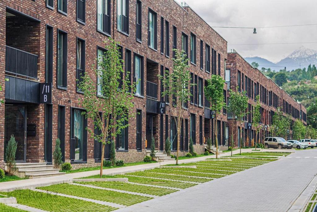 an empty street in front of a brick building at Manica Esentai City in Almaty