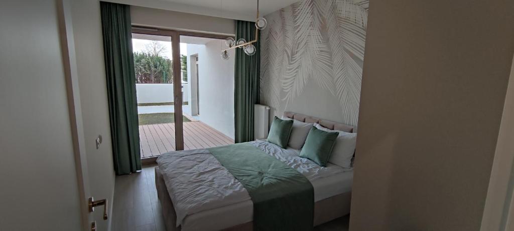 een slaapkamer met een bed met groene en witte kussens bij Nowoczesny apartament 07 in Sianozety