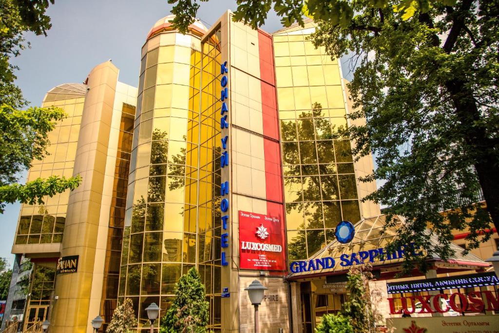 un edificio con un cartel en la parte delantera en Grand Sapphire Hotel, en Almaty