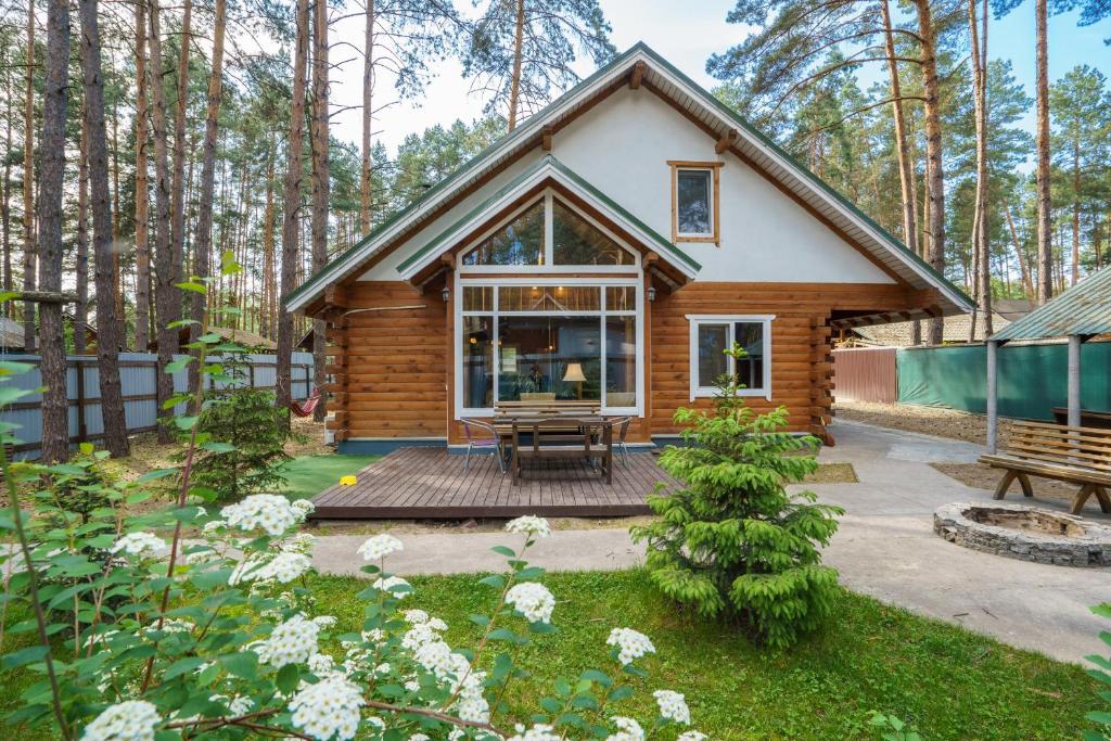 a log cabin in the woods with a deck at Ekodom in Voropayev