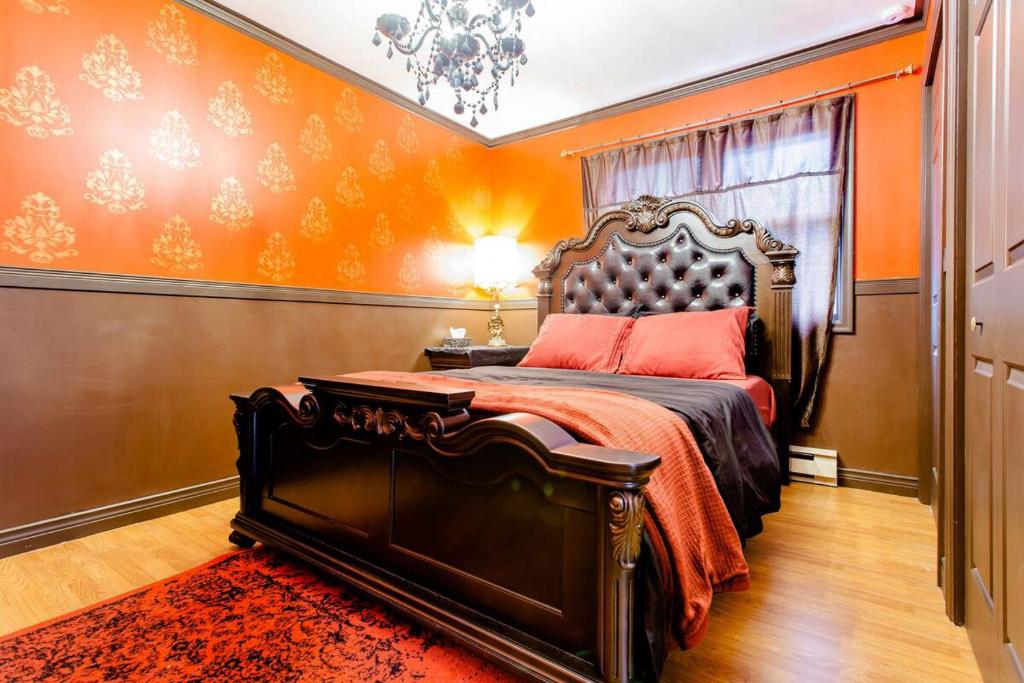 Private 3 bedrooms, Free parking, Private bathroom في Lower Sackville: غرفة نوم بسرير بحائط برتقالي