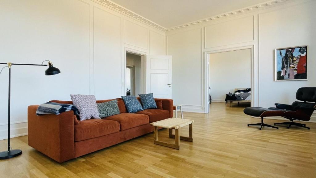uma sala de estar com um sofá castanho e uma mesa em ApartmentInCopenhagen Apartment 1542 em Copenhague