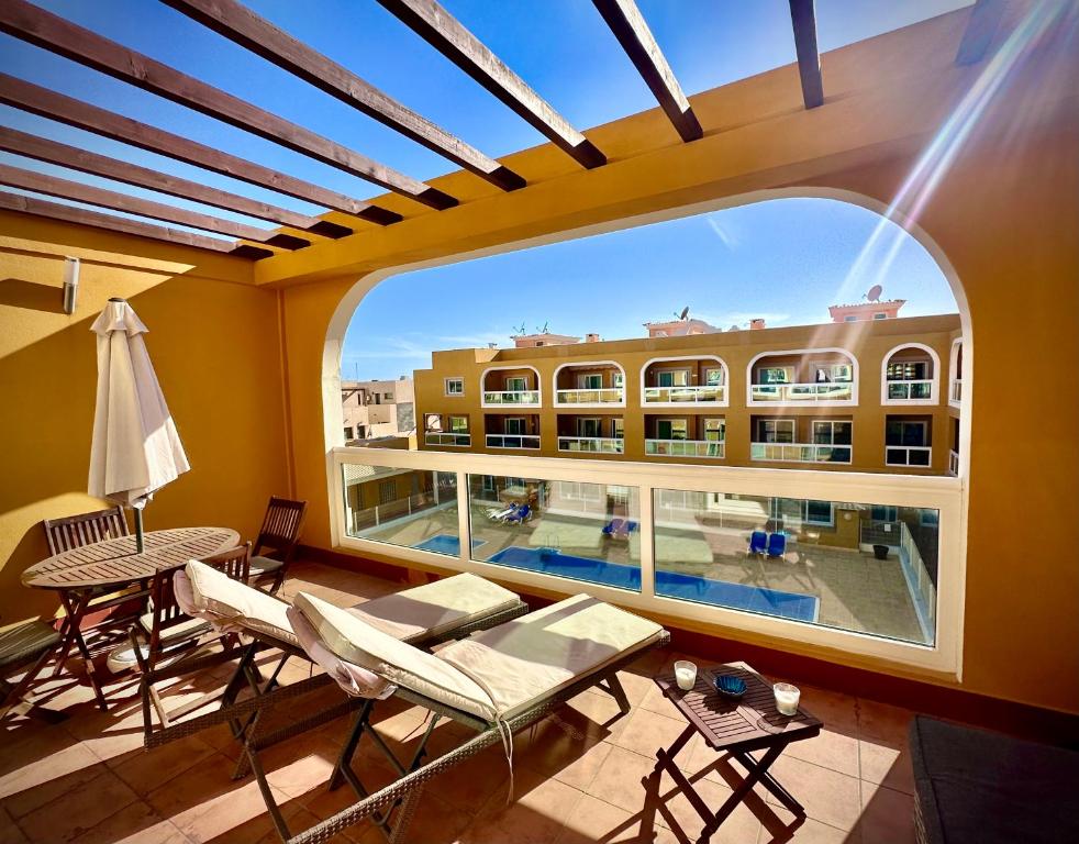 een balkon met uitzicht op een zwembad en een gebouw bij Turquesa Cotillo in Cotillo