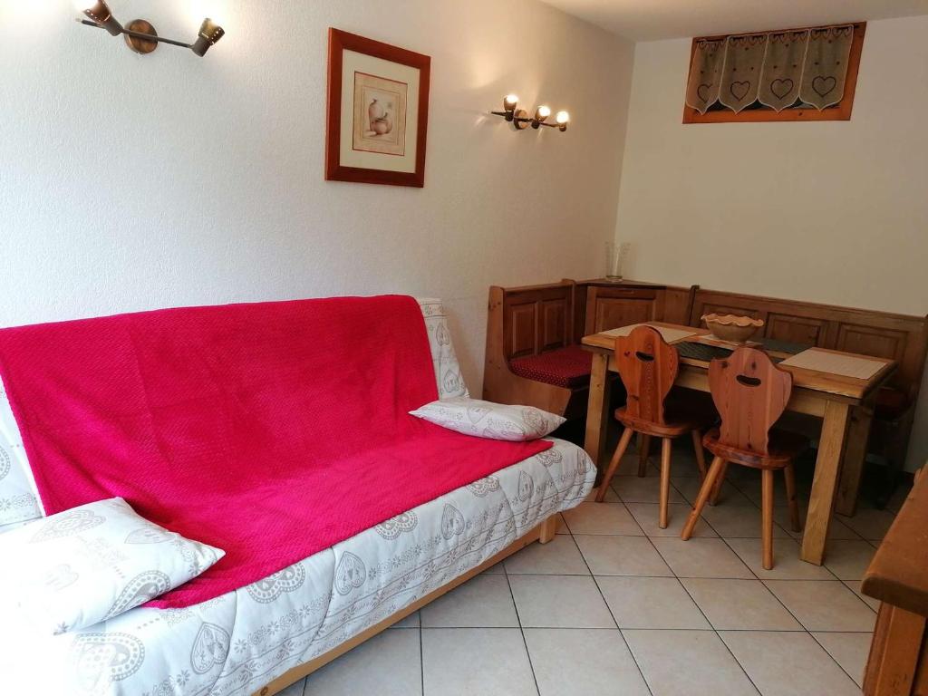 ル・グラン・ボルナンにあるAppartement Le Grand-Bornand, 2 pièces, 6 personnes - FR-1-241-111のベッド1台、テーブル(赤毛布付)が備わる客室です。