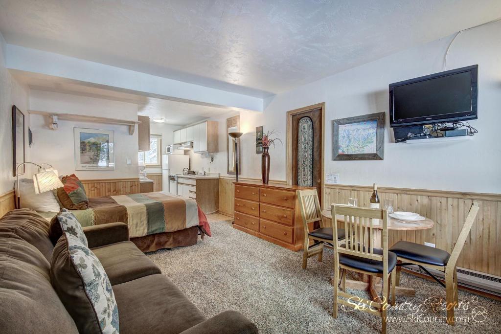 uma sala de estar com um sofá, uma cama e uma televisão em Affordable and Cozy Condo Steps from Main Street with Spacious Lobby, Hot Tubs PM3B em Breckenridge