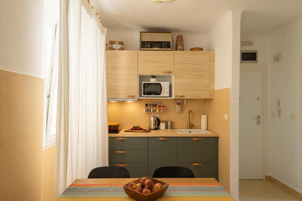 Pula City Apartment with private parking FREE في بولا: مطبخ صغير مع طاولة مع وعاء من الفواكه عليها