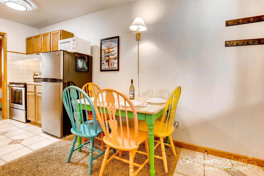 uma cozinha com uma mesa com cadeiras e um frigorífico em Economical, Cozy Condo Near Main St Access to Spacious Lobby, Hot Tubs PM5B em Breckenridge