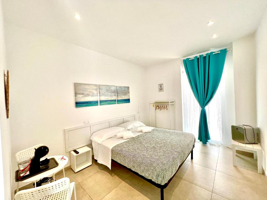 1 dormitorio con 1 cama y TV. en Le 4 Stagioni rooms, en Francavilla al Mare