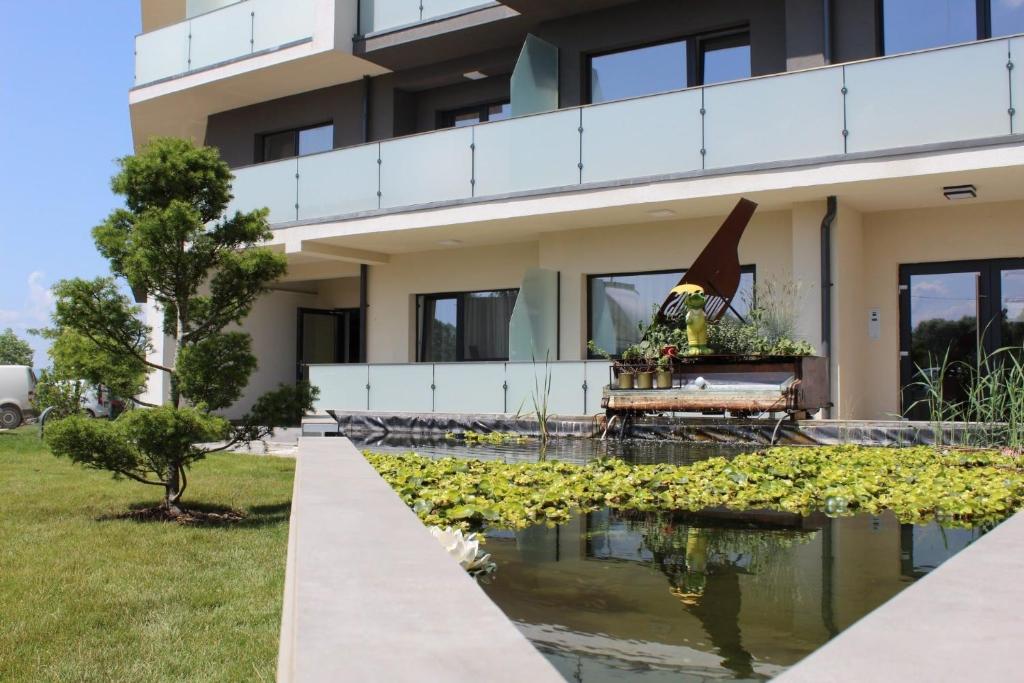 a house with a pond in front of it at KOA - NorthSide Apartment in Braşov