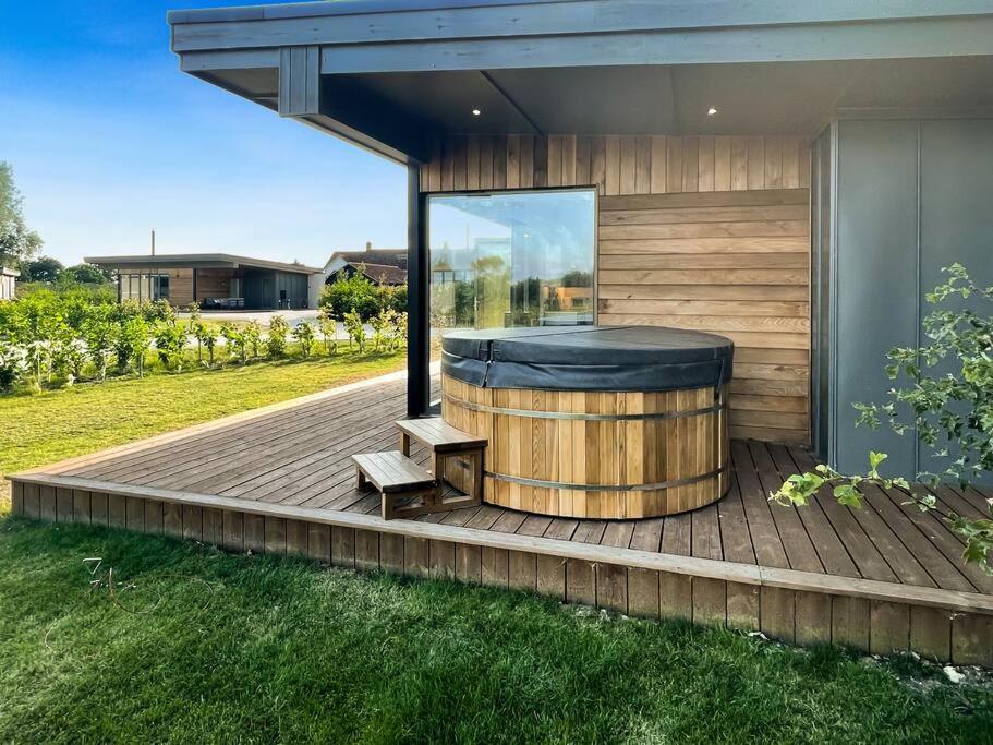 a hot tub sitting on a wooden deck at "Brett" Scandinavian Lodge with private hot tub in East Bergholt