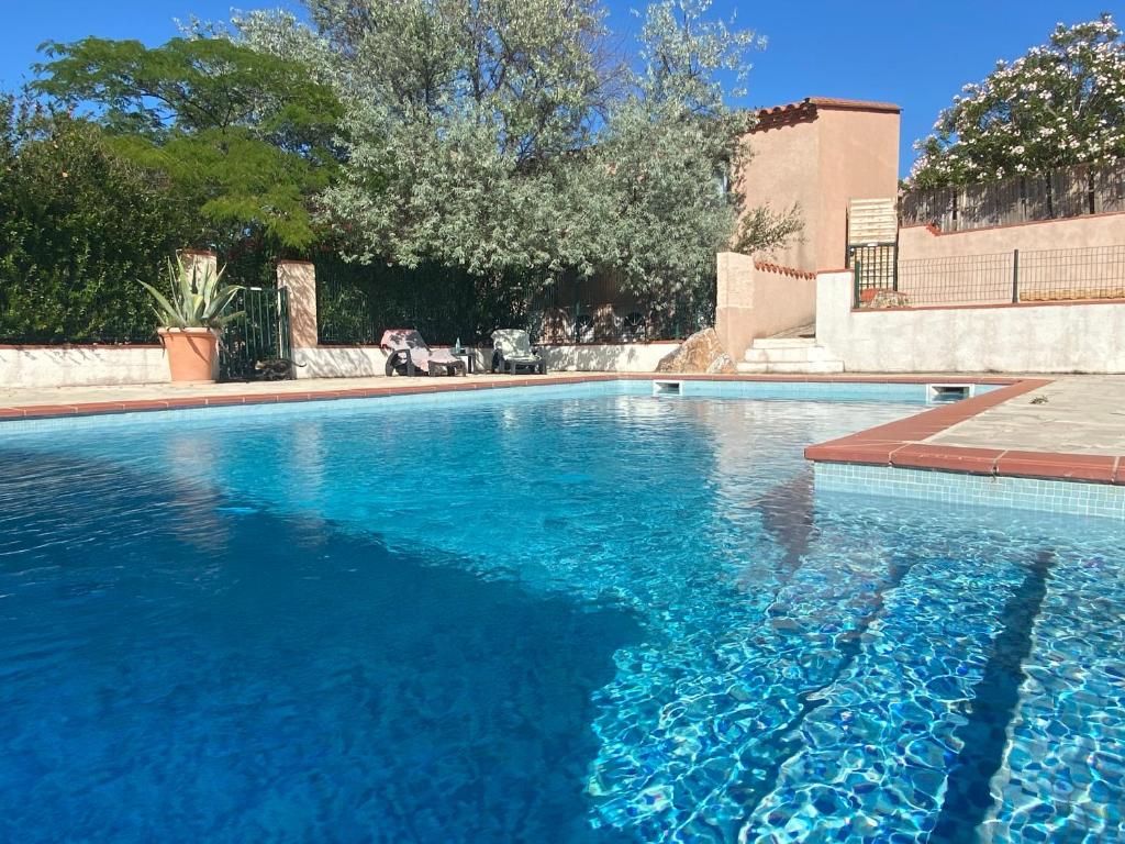 - une piscine d'eau bleue dans la cour dans l'établissement Cases des oliviers, à Cases-de-Pène