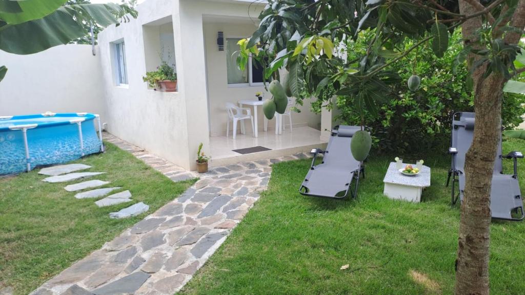 un patio trasero con piscina, mesa y sillas en Casa taina, en Jarabacoa