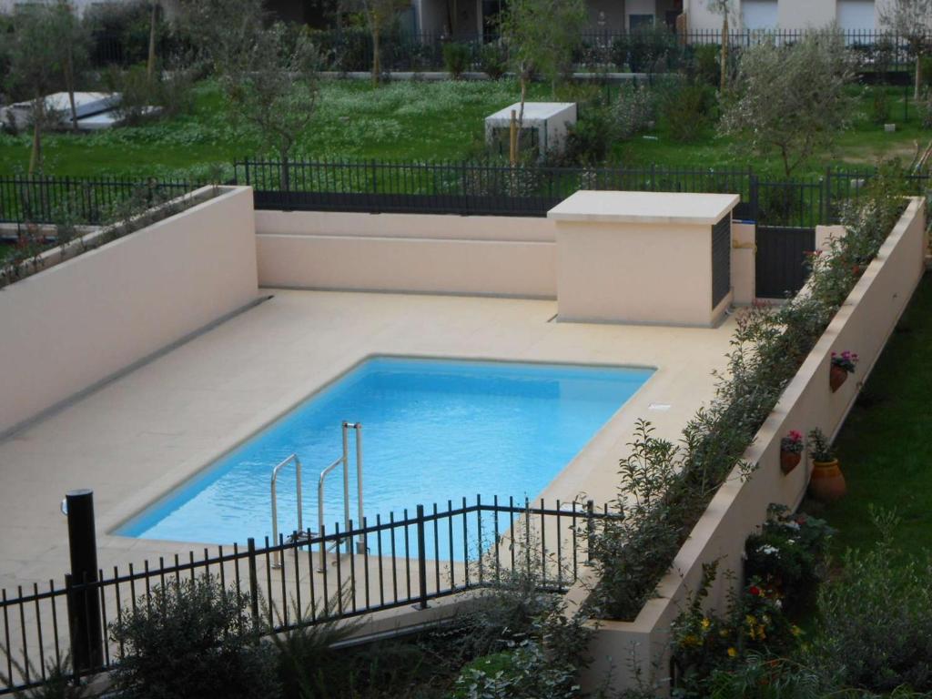 a swimming pool in a backyard with a fence at Appartement Saint-Raphaël, 3 pièces, 4 personnes - FR-1-226A-274 in Saint-Raphaël