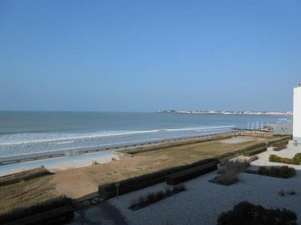 - une vue sur la plage avec un phare et l'océan dans l'établissement Beau T2 face mer, balcon, accès direct plage, St Gilles Croix de Vie - FR-1-324-125, à Saint-Gilles-Croix-de-Vie