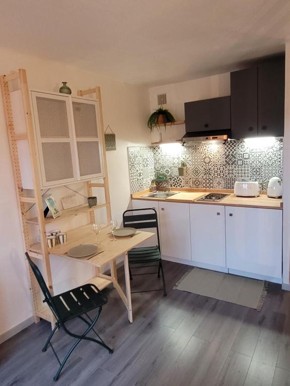 een kleine keuken met een houten tafel en stoelen bij Appart cocooning proche centre avec Parking in Hyères