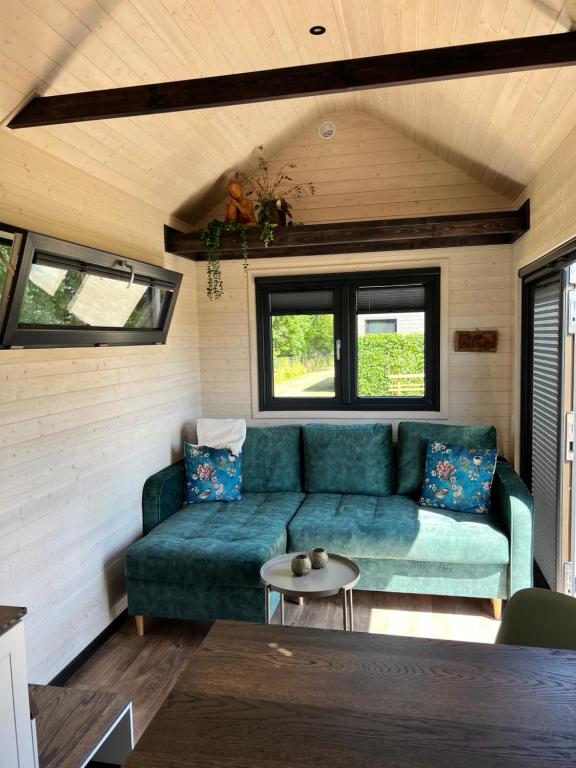 uma sala de estar com um sofá numa pequena casa em Tiny House Lovely Sunshine em Giethoorn