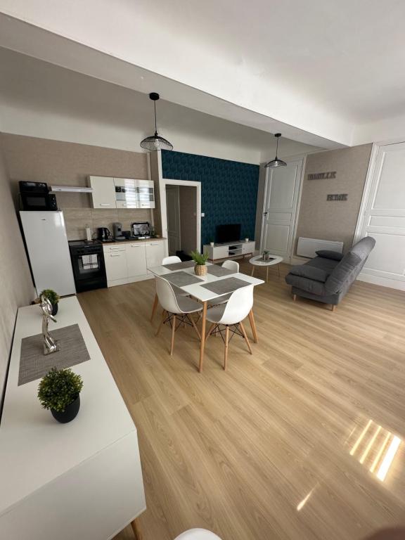 uma cozinha e sala de estar com mesa e cadeiras em Le Rétro em Saint-Laurent-sur-Saône