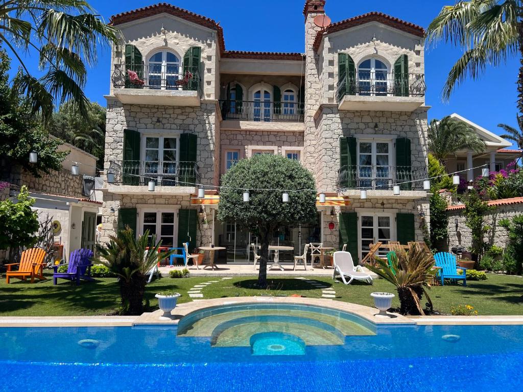 a large house with a swimming pool in front of it at YuGa Alacati in Alacati