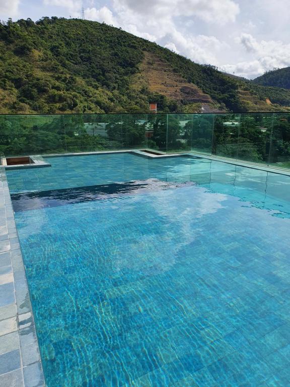 een groot zwembad met een berg op de achtergrond bij Cobertura Piemonte in Itaipava