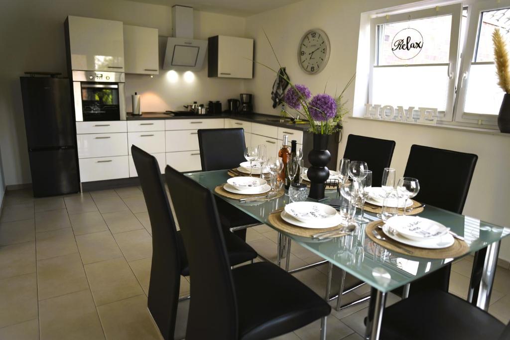 a dining room with a table and chairs and a kitchen at Ferienwohnung an der Steinfurter Aa in Steinfurt