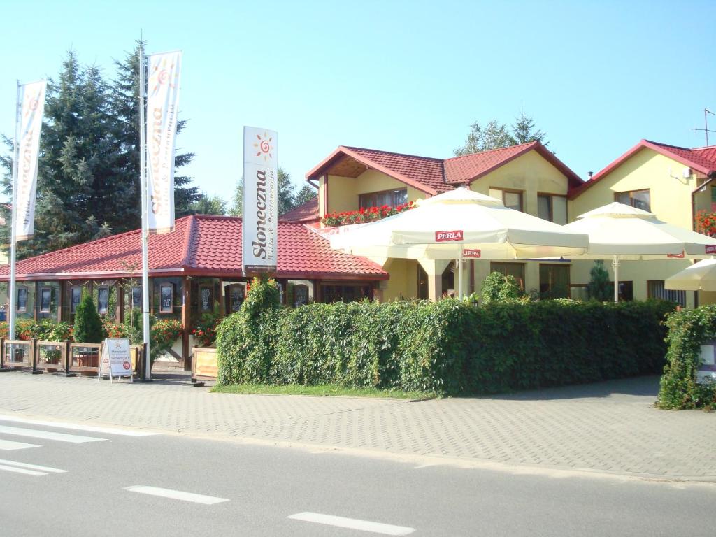 a building with umbrellas on the side of a street at Willa Słoneczna in Okuninka