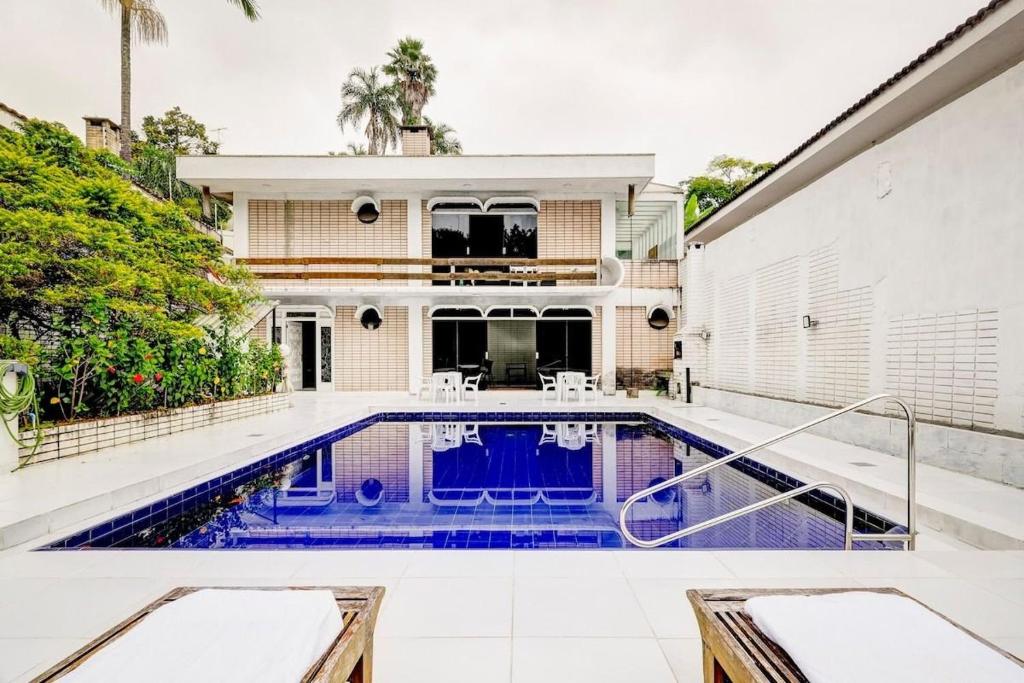 a swimming pool in front of a house at Mansão com vista para a Mata Atlântica in Sao Paulo