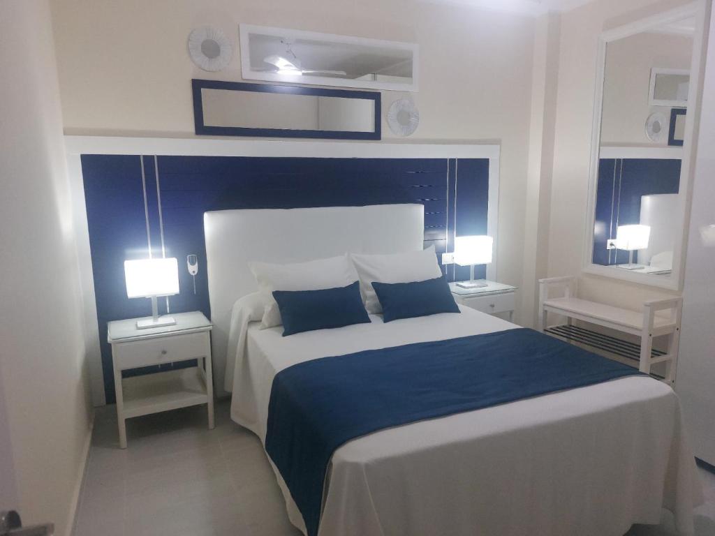 1 dormitorio con 1 cama grande y 2 lámparas en La Palma en Tarajalejo