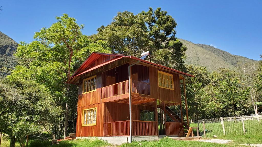 una casa en el árbol con una montaña en el fondo en Colina Verde House, en Chontabamba