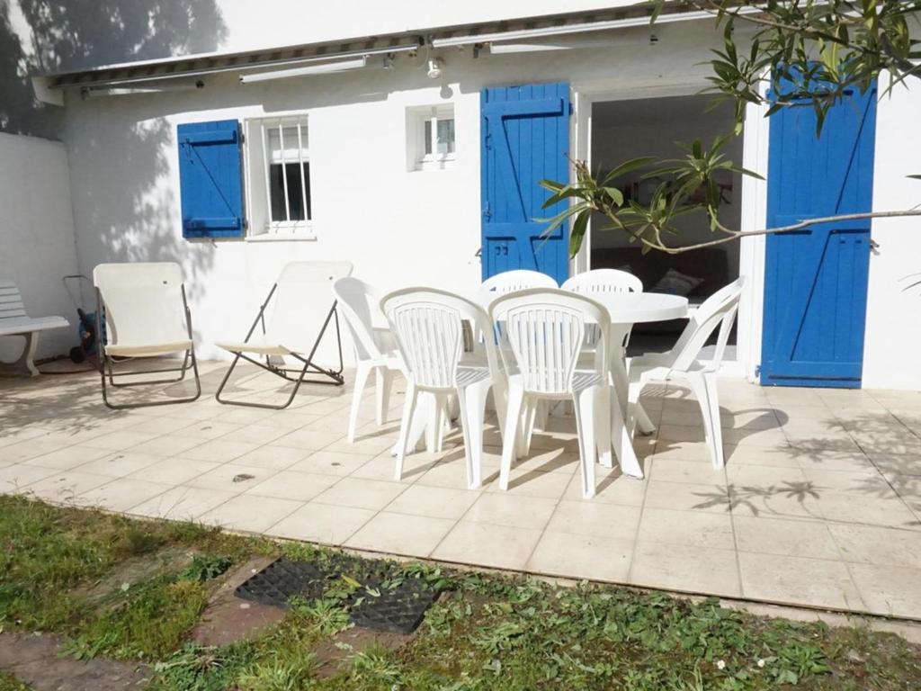 d'une terrasse avec des chaises blanches et une table. dans l'établissement Charmant 2 pièces à 100m de la plage avec jardin, terrasse et activités familiales - FR-1-224B-135, à La Guérinière