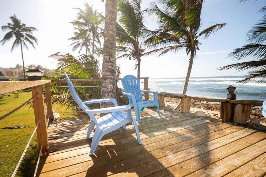 Dos sillas azules sentadas en una terraza con vistas al océano en Ocean Front Villa, 2 Private Pools, BBQ, Tennis court and more!, en Vega Baja