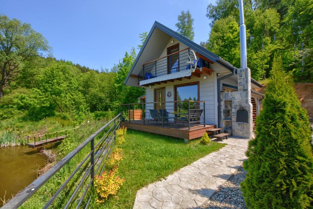 a small house with a porch and a balcony at Domki pod lasem w Wojtkowej in Wojtkowa