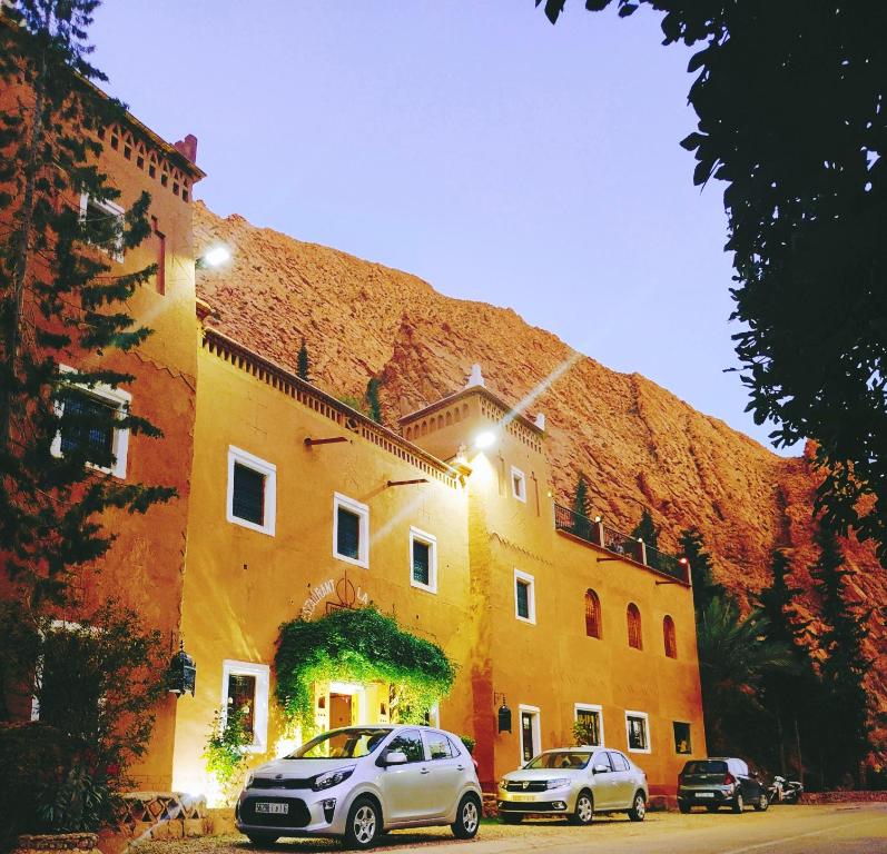 dos coches estacionados frente a un edificio en Auberge La Fibule Du Dades, en Aït Idaïr