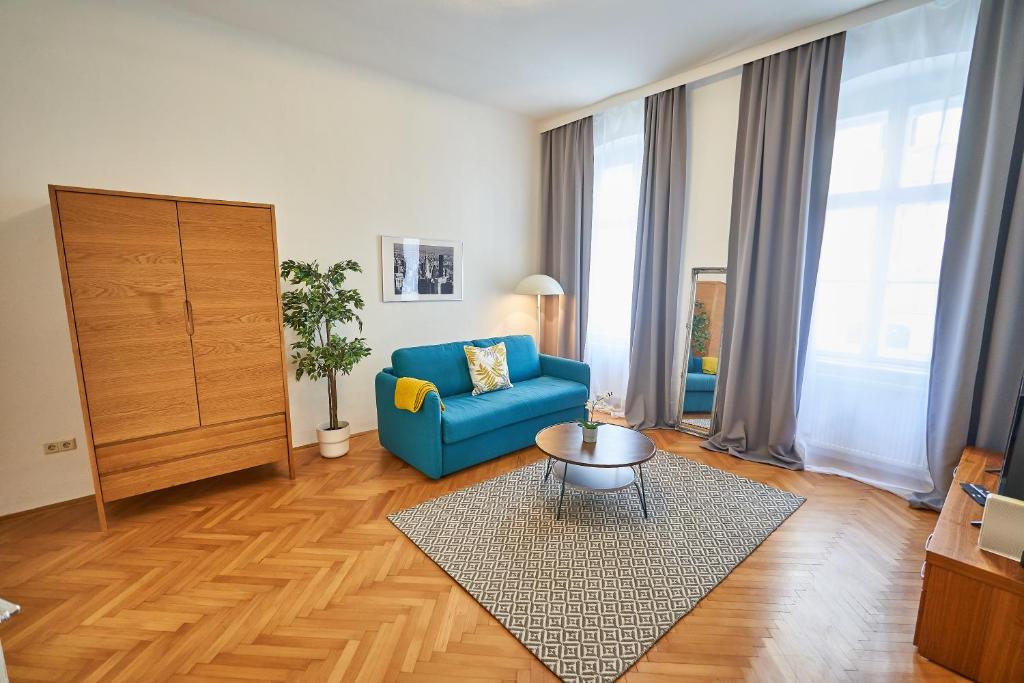 un soggiorno con divano blu e tavolo di Renovated & Cozy - Close to Museumsquartier a Vienna