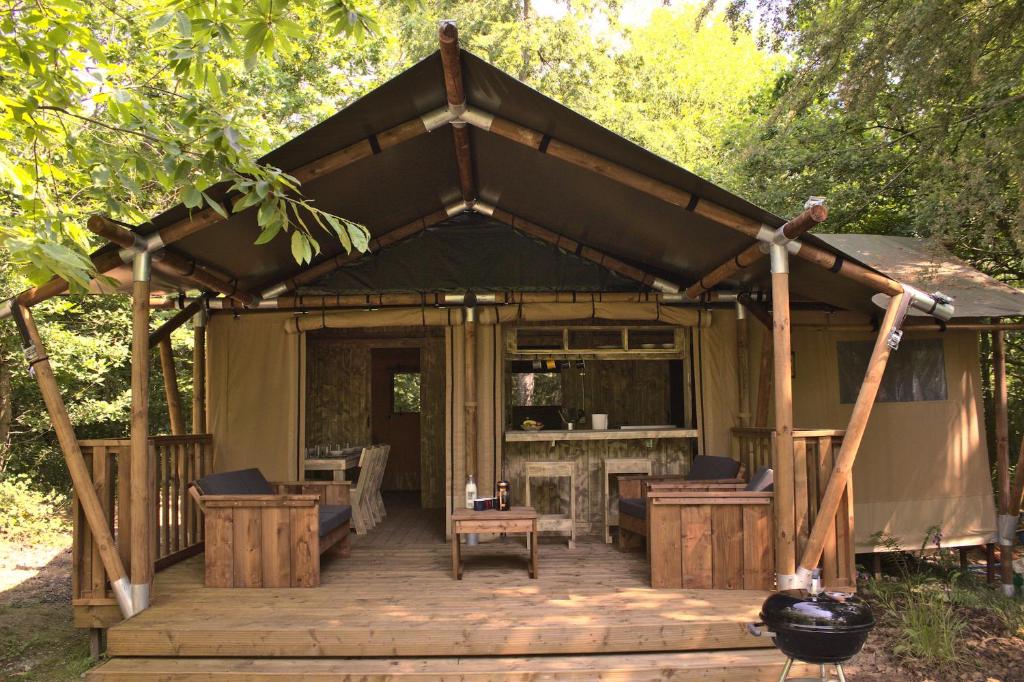 a gazebo with a table and chairs on a wooden deck at Luxury Safari Tent with Hot Tub in Ancient Woodland in Acton Scott