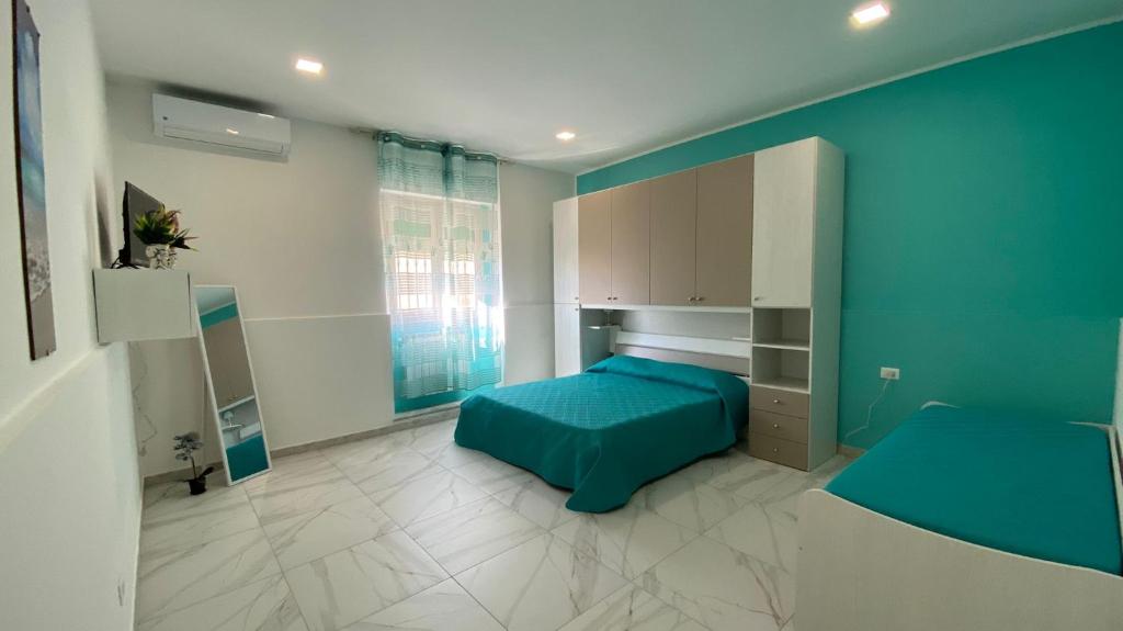 een slaapkamer met een bed en een blauwe muur bij La dimora dei Mori Gela in Gela