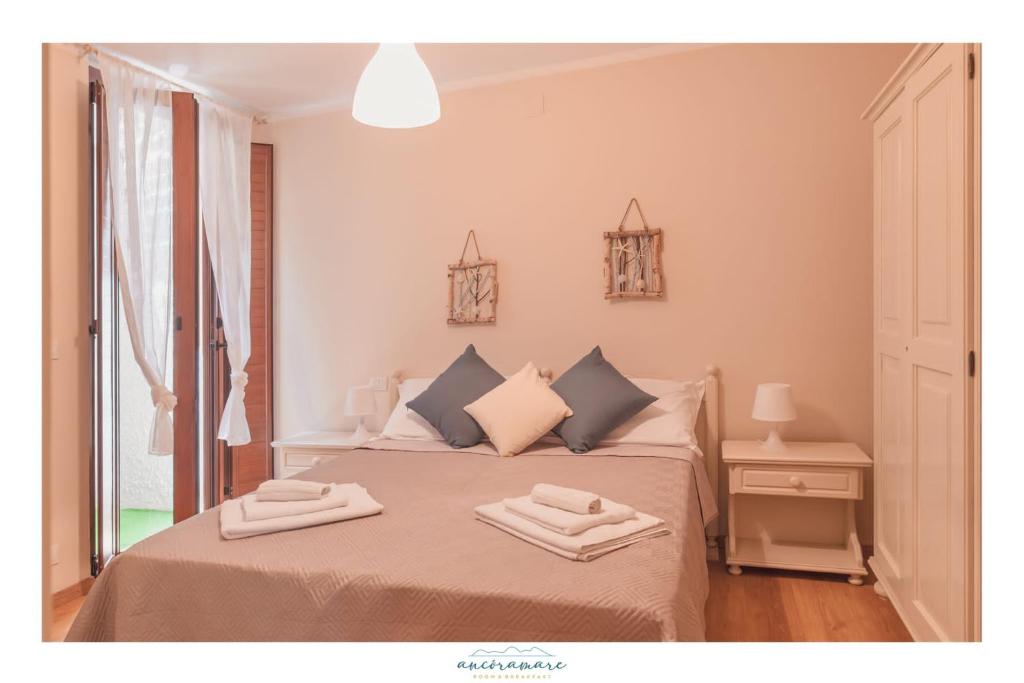 a bedroom with a bed with two towels on it at Ancóramare in Stintino