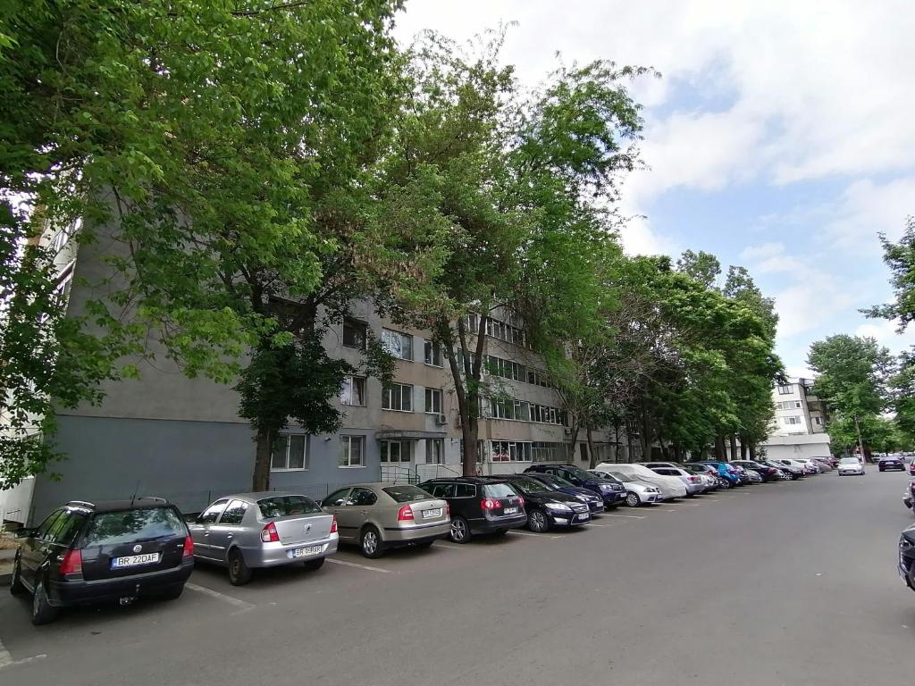 una fila de autos estacionados al lado de una calle en Concordia Apartament, en Brăila