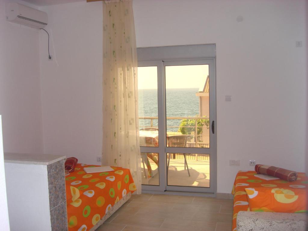a room with a balcony with a view of the ocean at Apartment Sorelle in Utjeha