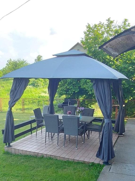 a table and chairs under a large blue umbrella at Apartman Danny in Slunj