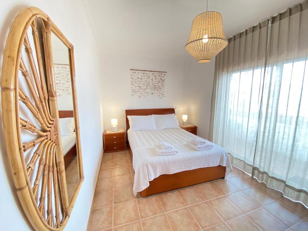 ein Schlafzimmer mit einem Bett und einem großen Spiegel in der Unterkunft Aloha Burgau Guesthouse in Burgau
