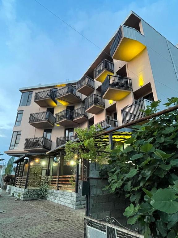 New House Kobuleti 2 في كوبوليتي: مبنى فيه بلكونات جنبه