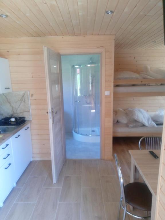 a room with a kitchen and a bathroom with a shower at Domki Bieszczady Całoroczne in Olszanica