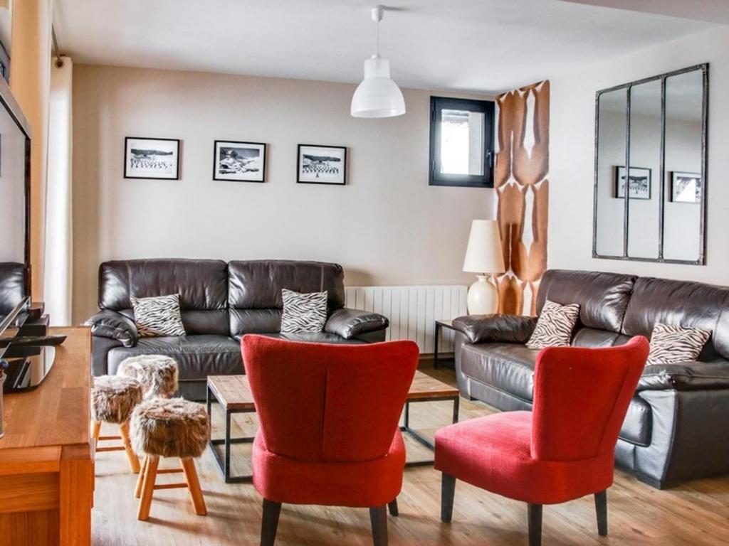 a living room with a leather couch and red chairs at Appartement La Mongie, 6 pièces, 12 personnes - FR-1-404-109 in La Mongie