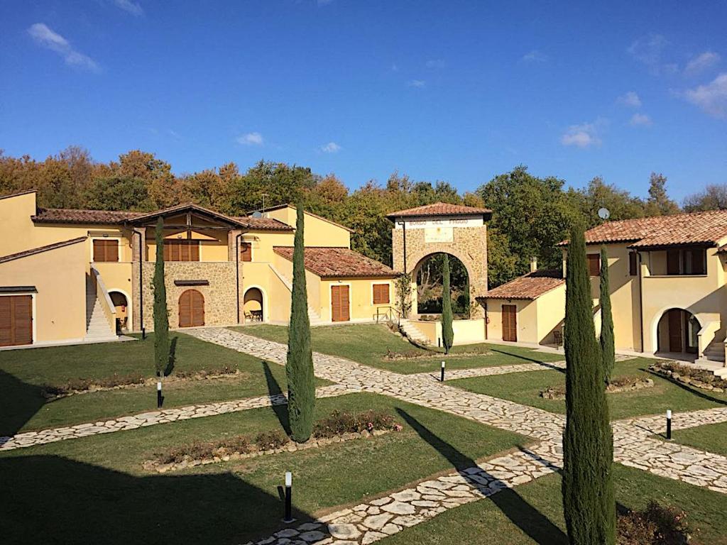 a group of buildings with trees in a yard at Appartamento - La Vinaccia in Montepulciano