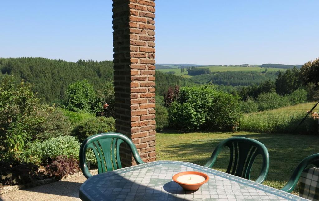 a table and chairs with a view of the countryside at Carpe Diem in Bullange