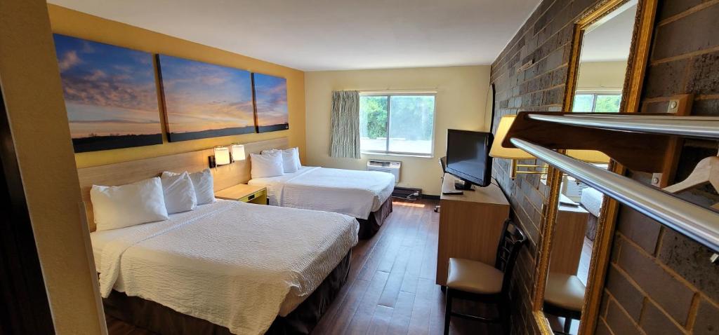 um quarto de hotel com duas camas e uma televisão em Days Inn by Wyndham Rockford em Rockford