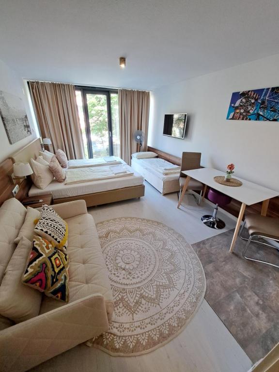 ein Wohnzimmer mit einem Sofa und einem Tisch in der Unterkunft Jezza Apart Suite in München