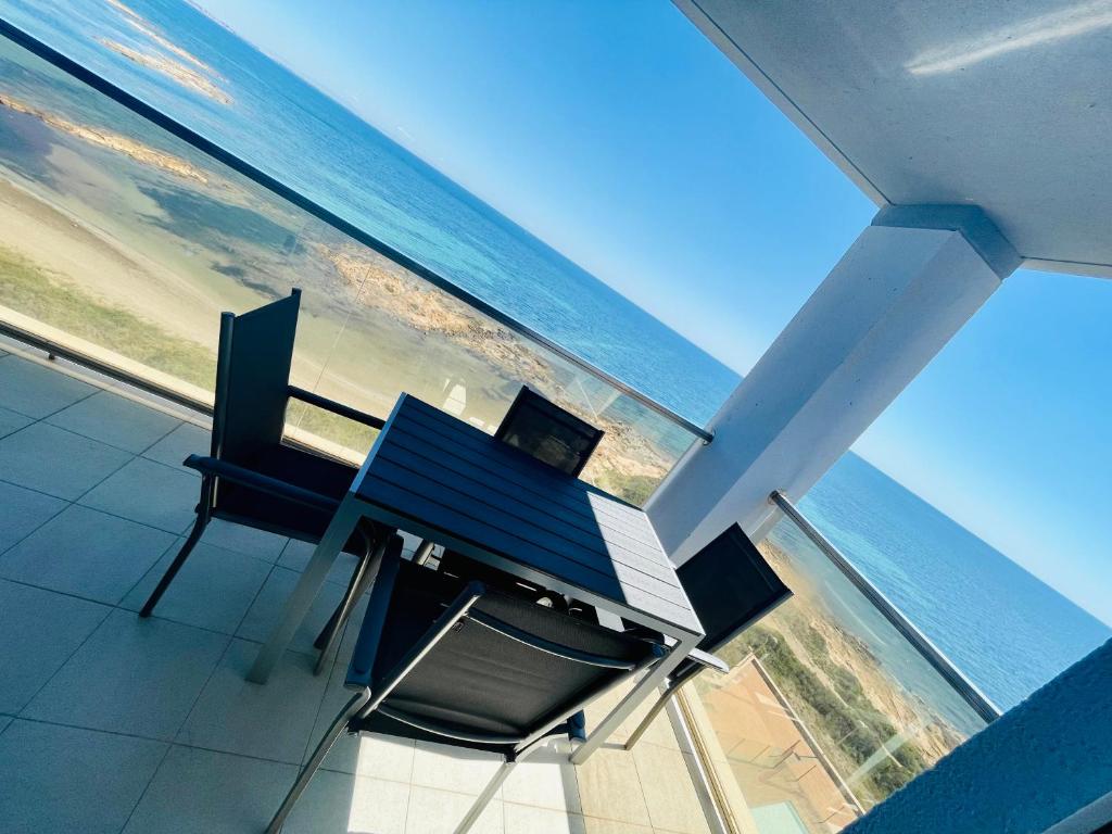 a view of the ocean from a table and chairs at Seafront La Manga Apartment in La Manga del Mar Menor